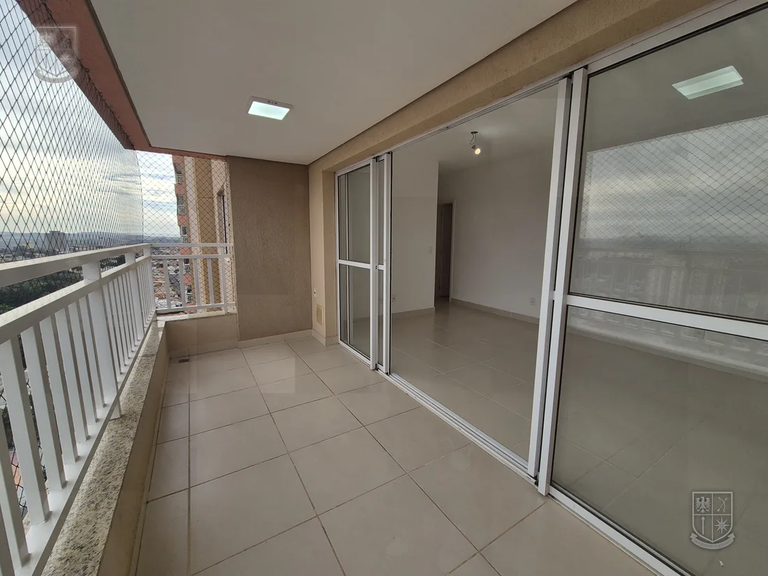 Varanda ampla com tela de proteção e vista aberta da cidade.