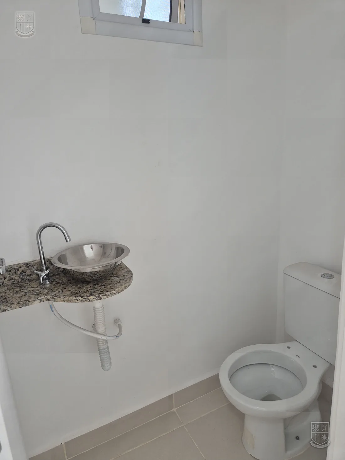 Banheiro com revestimento e louça instalados.