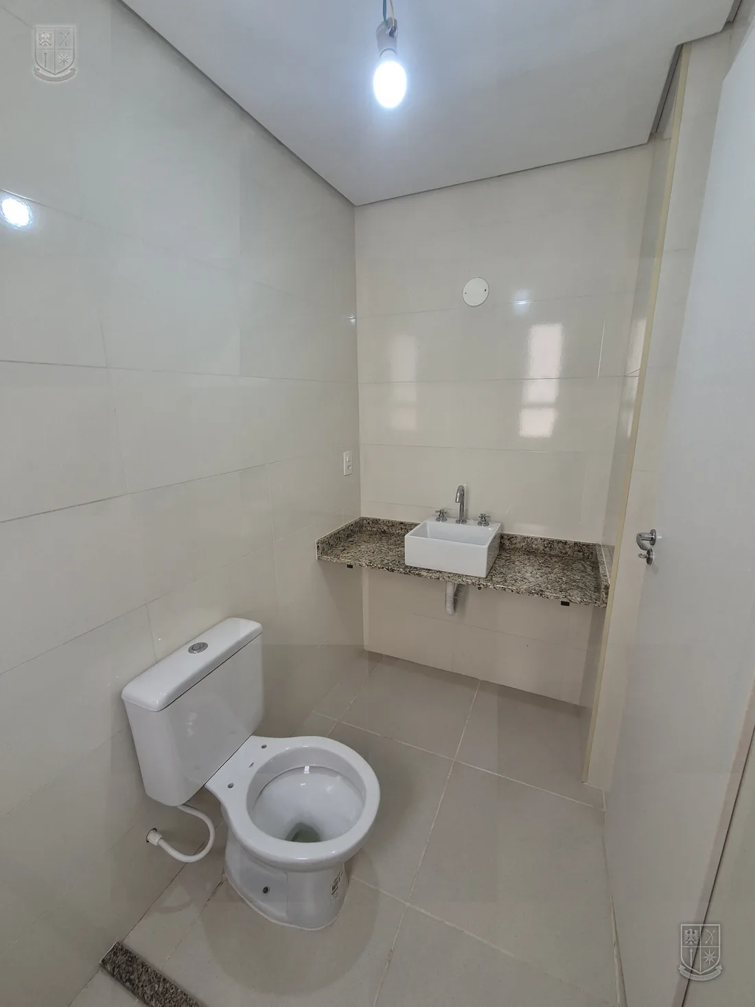 Banheiro do apartamento, com bancada e espelho.