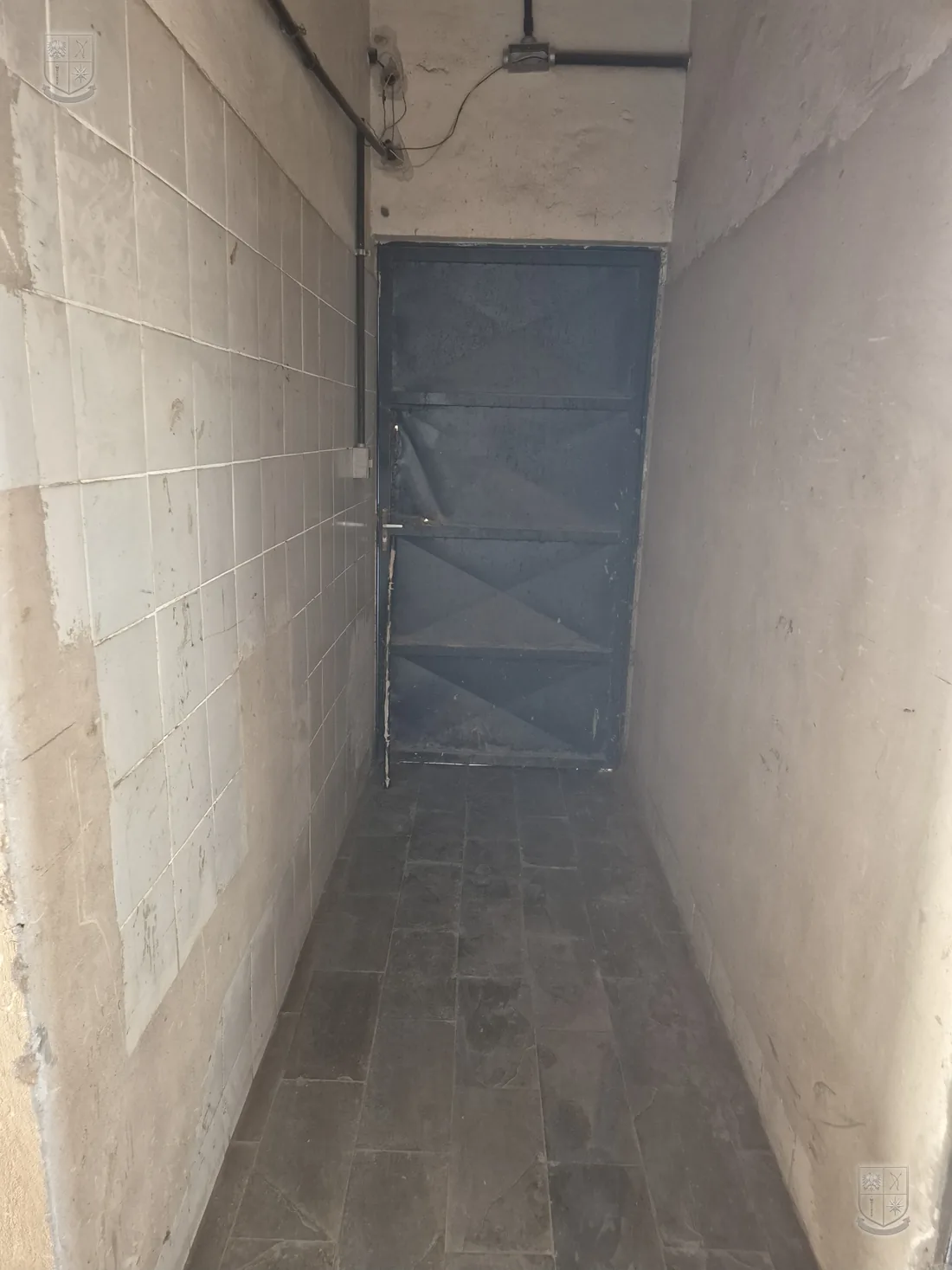 Corredor de circulação interna, com piso de concreto.